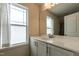 Bright bathroom featuring a large mirror, a single sink vanity, and natural light from a window at 5638 Wade Park Blvd, Raleigh, NC 27607