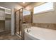 Bathroom features a soaking tub, glass enclosed shower, and walk in closet at 5638 Wade Park Blvd, Raleigh, NC 27607