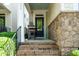 Inviting front porch with brick steps, a seating area, and stone accents on the home's facade at 5638 Wade Park Blvd, Raleigh, NC 27607