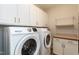Bright laundry room equipped with modern Samsung washer and dryer and white cabinets at 5638 Wade Park Blvd, Raleigh, NC 27607