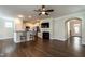 Open living room view featuring hardwood floors, modern kitchen bar, and fireplace with mounted television at 5638 Wade Park Blvd, Raleigh, NC 27607