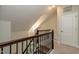 Upper staircase landing featuring a dark wood railing and a decorative light fixture at 5638 Wade Park Blvd, Raleigh, NC 27607