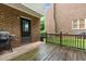 Home back deck showcasing brickwork, grill, and wood flooring at 6225 Waterside Ln, Raleigh, NC 27613