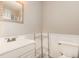 Half bathroom with white wainscoting, a vanity with sink, and chrome shelving unit at 6225 Waterside Ln, Raleigh, NC 27613