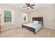 Bedroom features wood frame bed with blue bedding, beige carpet, and natural light at 6225 Waterside Ln, Raleigh, NC 27613