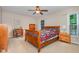 Cozy bedroom featuring a wood sleigh bed, a ceiling fan, and a bright window at 6225 Waterside Ln, Raleigh, NC 27613