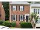 Charming brick townhouse with black shutters, offering a welcoming facade and a well-maintained front yard at 6225 Waterside Ln, Raleigh, NC 27613