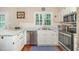 Bright kitchen with stainless steel appliances, white cabinetry, and a view of the backyard at 6225 Waterside Ln, Raleigh, NC 27613
