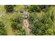 Aerial view of the property showing the house, barn, trees and a gravel driveway at 7404 Halifax Rd, Youngsville, NC 27596