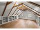 Spacious attic area with wood flooring, exposed beams, built in shelving and natural light at 7404 Halifax Rd, Youngsville, NC 27596