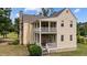 Rear exterior featuring multi-level porches and classic architecture with a stone chimney at 7404 Halifax Rd, Youngsville, NC 27596