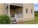 Cozy back porch with a white railing and stairs leading to the backyard at 7404 Halifax Rd, Youngsville, NC 27596