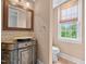 Charming powder room featuring decorative vanity with vessel sink and natural light from the window at 7404 Halifax Rd, Youngsville, NC 27596