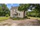 Side exterior view of the historic home with a stone chimney and mature trees at 7404 Halifax Rd, Youngsville, NC 27596