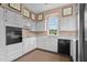 Cozy kitchen with white cabinets, black appliances, and a bright window with natural light at 7404 Halifax Rd, Youngsville, NC 27596