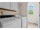 A bright laundry room featuring white washer and dryer, with natural light from a window at 7404 Halifax Rd, Youngsville, NC 27596