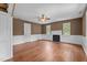 Living room featuring hardwood floors, baseboard trim, with three windows and a fireplace at 7404 Halifax Rd, Youngsville, NC 27596