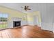 Bright living room features a fireplace, hardwood floors, and a ceiling fan for added comfort at 7404 Halifax Rd, Youngsville, NC 27596