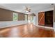 Large living room featuring hardwood floors, baseboard trim, with four windows and a ceiling fan at 7404 Halifax Rd, Youngsville, NC 27596