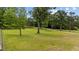 Expansive green lawn with mature trees and a long gravel driveway leading to the property at 7404 Halifax Rd, Youngsville, NC 27596