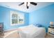 Bright blue bedroom featuring a ceiling fan and a large window at 80 Shambley Meadows Dr, Pittsboro, NC 27312