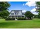 Charming two-story home features a wraparound porch and lush green landscaping under a clear blue sky at 80 Shambley Meadows Dr, Pittsboro, NC 27312