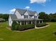Gorgeous two-story home featuring a spacious wraparound porch and meticulously manicured front yard at 80 Shambley Meadows Dr, Pittsboro, NC 27312