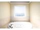 The luxurious main bathroom features a large soaking tub, tiled walls, and a window for natural light and added privacy at 80 Shambley Meadows Dr, Pittsboro, NC 27312