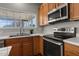 Kitchen view features stainless steel appliances, wood cabinets, and natural light from a window at 821 Stackhurst Way, Wake Forest, NC 27587