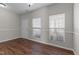 Well-lit living room featuring sleek hardwood floors and large windows, creating a welcoming atmosphere at 821 Stackhurst Way, Wake Forest, NC 27587
