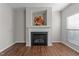 Cozy living room featuring a fireplace and mantle, with light gray walls and rich brown flooring at 821 Stackhurst Way, Wake Forest, NC 27587