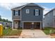Two-story home with a two-car garage, gray siding, black shutters, and a well-maintained front lawn at 848 Ottawa Dr, Garner, NC 27529
