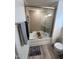 Bathroom with a shower-tub, ceramic tiled walls, and wood-look vinyl flooring at 99 Still Hand Dr, Clayton, NC 27527