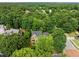 Aerial view of a two-story brick home nestled among lush trees, showcasing its curb appeal and serene surroundings at 100 Silver Lining Ln, Cary, NC 27513