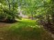 Picturesque backyard featuring a lush lawn and mature trees, creating a serene and private outdoor space at 100 Silver Lining Ln, Cary, NC 27513