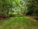 Lush backyard with mature trees providing ample shade, perfect for outdoor activities at 100 Silver Lining Ln, Cary, NC 27513