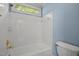 Full bathroom features a white tiled shower-tub and blue accent wall paint at 100 Silver Lining Ln, Cary, NC 27513