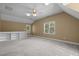 Spacious bonus room with carpet, fan, and a built-in bookcase at 100 Silver Lining Ln, Cary, NC 27513