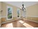 Dining room with hardwood floors, chandelier, and windows overlooking the backyard at 100 Silver Lining Ln, Cary, NC 27513