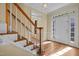 Bright foyer with hardwood floors and a staircase leading to the second floor, with white door and trim at 100 Silver Lining Ln, Cary, NC 27513