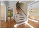 Sun-filled foyer with hardwood floors, staircase and chandelier with view to adjacent rooms at 100 Silver Lining Ln, Cary, NC 27513