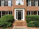 Close-up of the front door with brick steps and manicured bushes and shrubs at 100 Silver Lining Ln, Cary, NC 27513