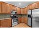 Kitchen featuring wood cabinets, granite countertops, and stainless steel appliances at 100 Silver Lining Ln, Cary, NC 27513