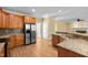 Kitchen featuring wood cabinets, granite countertops, stainless steel appliances, and hardwood floors at 100 Silver Lining Ln, Cary, NC 27513