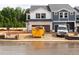 Two-story townhome exterior during construction, featuring a visible dumpster, construction equipment, and landscaping materials at 1027 Winding Spring Dr, Mebane, NC 27302
