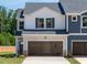 Charming two-story townhome features a large garage and a mix of white and blue siding at 1027 Winding Spring Dr, Mebane, NC 27302