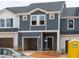 Modern townhome featuring blue siding, stone accents, open garage and covered front entry at 1029 Winding Spring Dr, Mebane, NC 27302