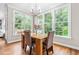 Cozy dining area with large windows, a modern light fixture, and seating for four at 104 Edgewater Cir, Chapel Hill, NC 27516