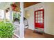 Inviting front porch with hanging plants, egg chairs, and a bright red front door at 104 Edgewater Cir, Chapel Hill, NC 27516