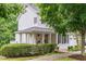 Inviting white home with a charming front porch featuring hanging flower baskets and stylish egg chairs at 104 Edgewater Cir, Chapel Hill, NC 27516